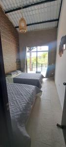 a bedroom with two beds and a large window at Villa Jana Casa campestre cerca a Villeta in Quebradanegra