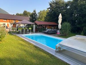 a swimming pool in a yard next to a house at Pension Hutterer in Scharnstein