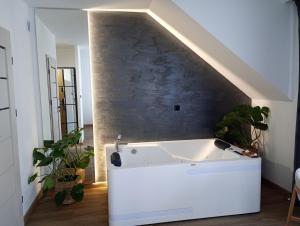 a white bath tub in a room with plants at Kaszmirowe Mini Spa in Augustów
