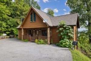 una baita di tronchi con un vialetto davanti ad essa di Valley View Lodge by American Patriot Getaways a Hatchertown