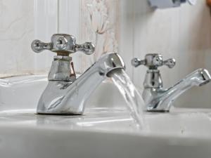 a bathroom sink with two faucets on it at Whiteside 3 Bedroom Apartment - Bathgate in Bathgate +33 photos