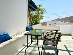 a balcony with a glass table and two chairs at Anemochadi in Agios Sostis