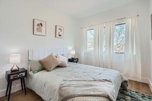 Un dormitorio blanco con una cama y dos ventanas. en Luxury Downtown Oasis, Pool Table, Near Riverwalk, en San Antonio