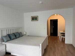 a bedroom with a white bed and a table at Ferienwohnung Sofi in Bad Reichenhall