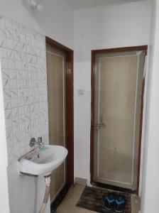 a bathroom with a sink and a glass shower door at Entire 1BHK Flat Home Stay in Nashik