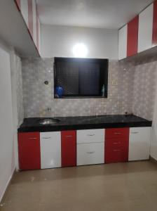 a kitchen with red and white cabinets and a sink at Entire 1BHK Flat Home Stay in Nashik