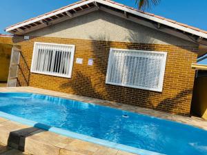 a swimming pool in front of a house at Casa da vovó Marta in Itanhaém