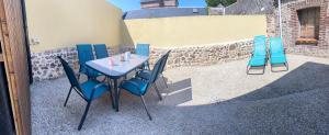 a table and chairs sitting next to a building at Welc'Home in Saint-Valéry-en-Caux +2 photos