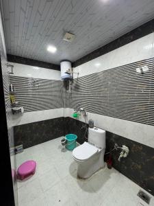 baño con aseo y taburete rosa en The luxe loft, en Jaipur