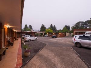 a parking lot with cars parked in front of a building at 3 Sisters Motel in Katoomba