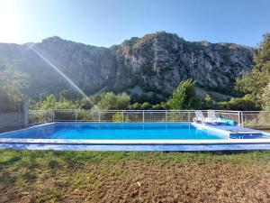 Ein Swimmingpool mit einem Berg im Hintergrund in der Unterkunft Vila Arapović, Maloševići 56 in Buna