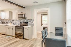 a kitchen with white cabinets and a table with chairs at Less Than 1 Mi to EverBank Stadium Retreat with Yard! in Jacksonville