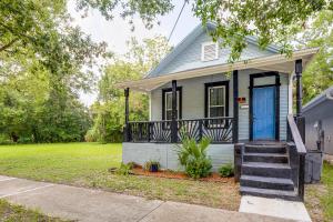 a small house with a blue door and stairs at Less Than 1 Mi to EverBank Stadium Retreat with Yard! in Jacksonville