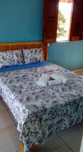 a bedroom with a bed with a black and white comforter at Pousada Aritibe in Ilha de Boipeba
