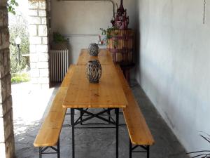 a long wooden table with two vases sitting on it at Marone Apartment with Pool in Marone