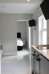 cocina blanca con cama de fondo en MOXIE LUXURY APARTMENTS, en Belfast