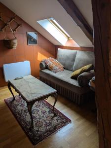 a living room with a couch and a table at Les Chanterelles La souris des champs in Étival-Clairefontaine