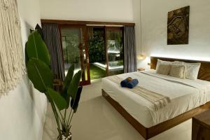 a bedroom with a bed with two blue balls on it at Villa Licia - Seseh area in Balian +41 photos