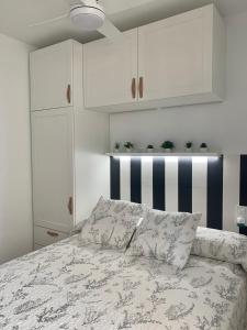 1 dormitorio con 1 cama y armarios blancos en Un pequeño lujo a pocos metros de la playa, en Piles