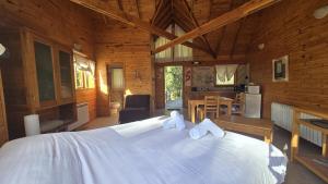 a bedroom with a large white bed in a cabin at BOG Altos de Antilhue - Apart con vista al bosque in Villa La Angostura +84 photos