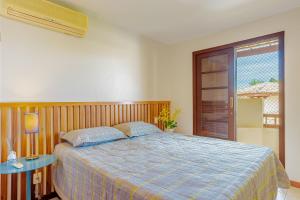 Un dormitorio con una cama con un edredón azul. en PF112 Magnífico apartamento frente al mar con 2 suites - Praia do Forte, en Praia do Forte 26 fotos más