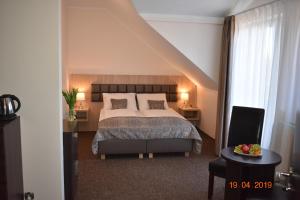 a bedroom with a bed and two tables and a staircase at Pensjonat Dolce Vita & SPA in Ustronie Morskie +24 photos