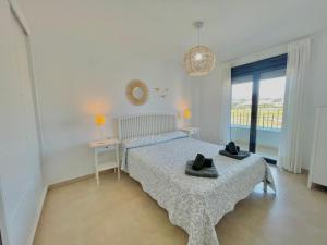 a bedroom with a bed with two hats on it at Terrasol Torre Del Mar Azucarera 4ª Planta in Torre del Mar +11 photos