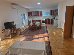 a living room with a table and a kitchen at Apartman Vujovic in Zlatište