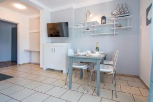 une cuisine et une salle à manger avec une table et des chaises bleues dans l'établissement Apartament Nostalgia, à Gąski