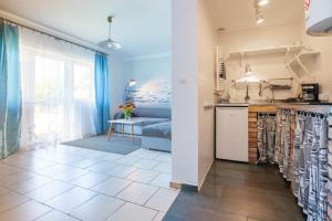 - une cuisine avec évier et un lit dans une chambre dans l'établissement Apartament Nostalgia, à Gąski