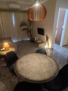 a living room with a table and chairs and a television at Tulip in flat SAN martain in Fortaleza