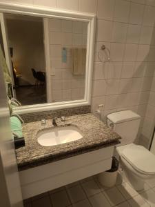 a bathroom with a sink and a toilet and a mirror at Tulip in flat SAN martain in Fortaleza +8 photos