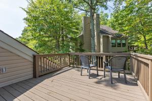 a wooden deck with two chairs and a house at Massanuttens Shenandoah Villas by TripForth in McGaheysville