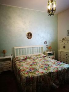 a bedroom with a bed with a floral bedspread at Hillside semi-detached villa with panoramic views in Schignano