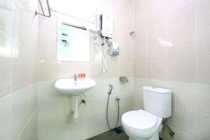 a white bathroom with a toilet and a sink at Midah Inn Puchong in Puchong +15 photos