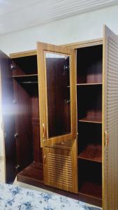 d'un meuble en bois avec une porte en verre dans la chambre. dans l'établissement Mini Meublé au rez de chaussée, à Dakar