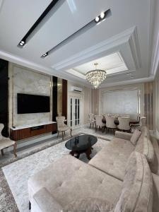 un salon avec un canapé et une télévision dans l'établissement Tashkent City Apartments D11, à Tachkent