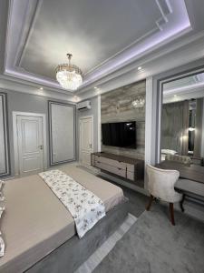a large bedroom with a large bed and a chandelier at Tashkent City Gardens Residence D11-4-27 in Tashkent +19 photos