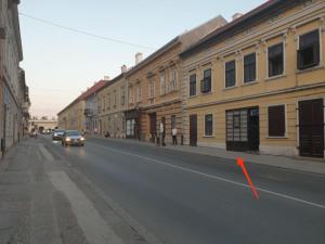 a car driving down a city street with a red arrow at RetroDream in Petrovaradin