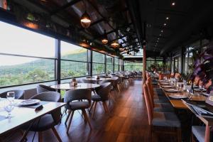 a restaurant with tables and chairs and large windows at Villa Vista in Bitola