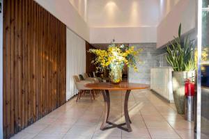 a vase of flowers on a table in a room at Celita Franca - WS Urban in Feira de Santana