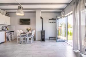 a kitchen and dining room with a table and chairs at Nemo - apartament, domek w Gaskach in Gąski +17 photos