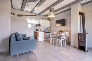 a living room and kitchen with a couch and a table at Nemo - apartament, domek w Gaskach in Gąski
