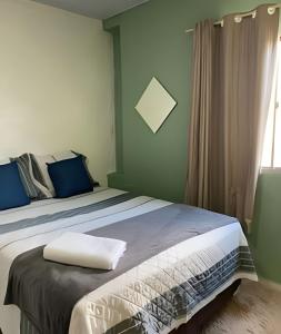 a bedroom with a bed with blue walls and a window at Studio Compac. | Shoppings | Centro | Arena | Aero in Manaus