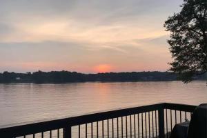 シャーロットにあるSunset Shores Retreatの水面に沈む夕日