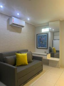 ein Wohnzimmer mit einer Couch und einem Spiegel in der Unterkunft APART HOTEL MANAÍRA PALACE in João Pessoa