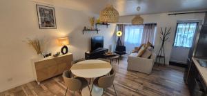 a living room with a table and a couch at Le ST Martin, Appartement de 45 m avec chambre séparé in Mayenne +12 photos