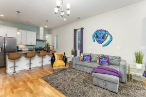 a living room with a couch and a kitchen at Queen City's Nest Uptown in Charlotte