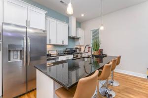 a kitchen with white cabinets and a stainless steel refrigerator at Queen City's Nest Uptown in Charlotte