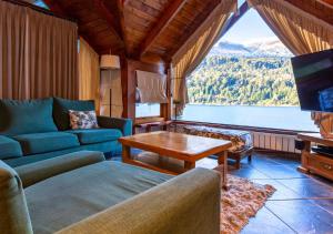 a living room with a couch and a table at Costa Serena Aparts & Spa in Villa La Angostura